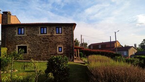 Un edificio in pietra con un piccolo giardino e un vialetto che vi conduce.
