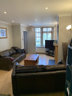 living room with 2 leather sofas   50 inch TV 