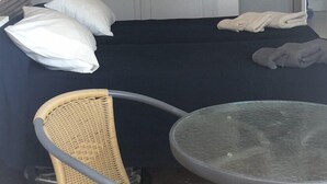 Une chambre à coucher avec un lit, des oreillers, une chaise et une petite table.