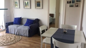 Una sala de estar acogedora con un sofá, una mesa de comedor y una pequeña cocina.