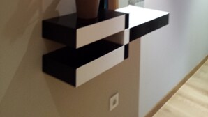 Ein modernes Interieur mit einer eingebauten Ablagefläche, auf der sich ein Blumentopf und ein Spiegel befinden.