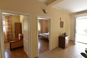 A hallway with a wooden floor, a chair, a bed, and a small cabinet. - Villa Maria, Punta-Umag, swimming pool, near the sea, WiFi, air-conditioned (Umag)
