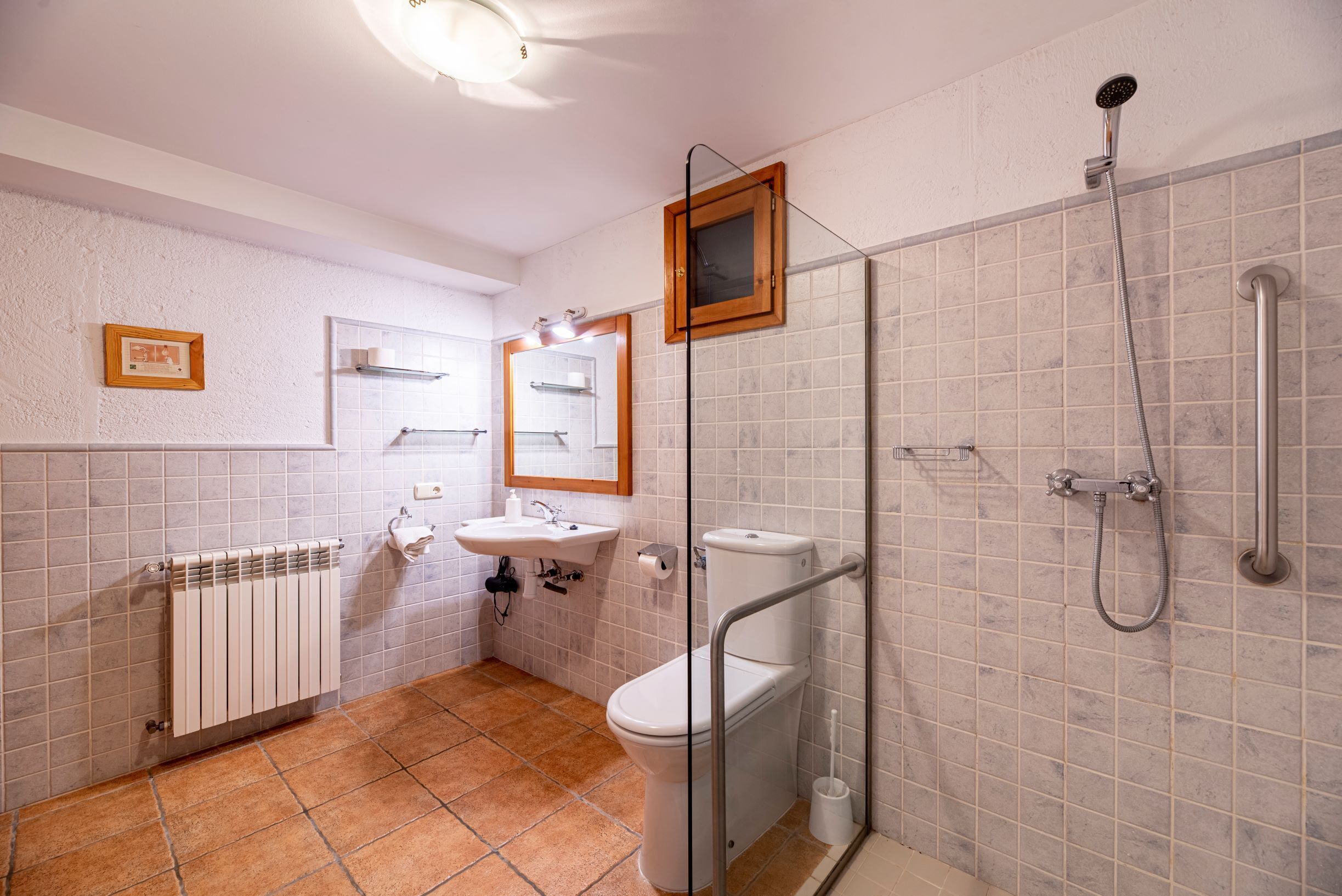A bathroom with a toilet, sink, and shower.