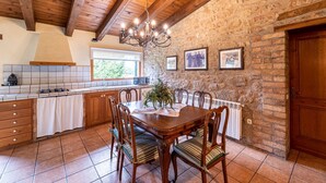 A rustic kitchen with a wooden table, chairs, and a chandelier. - Casa Corral for 6 people (Lladurs)