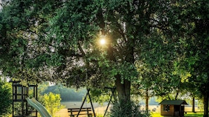 A park with a wooden swing set, a slide, and a small cabin. - Casa Corral for 6 people (Lladurs)