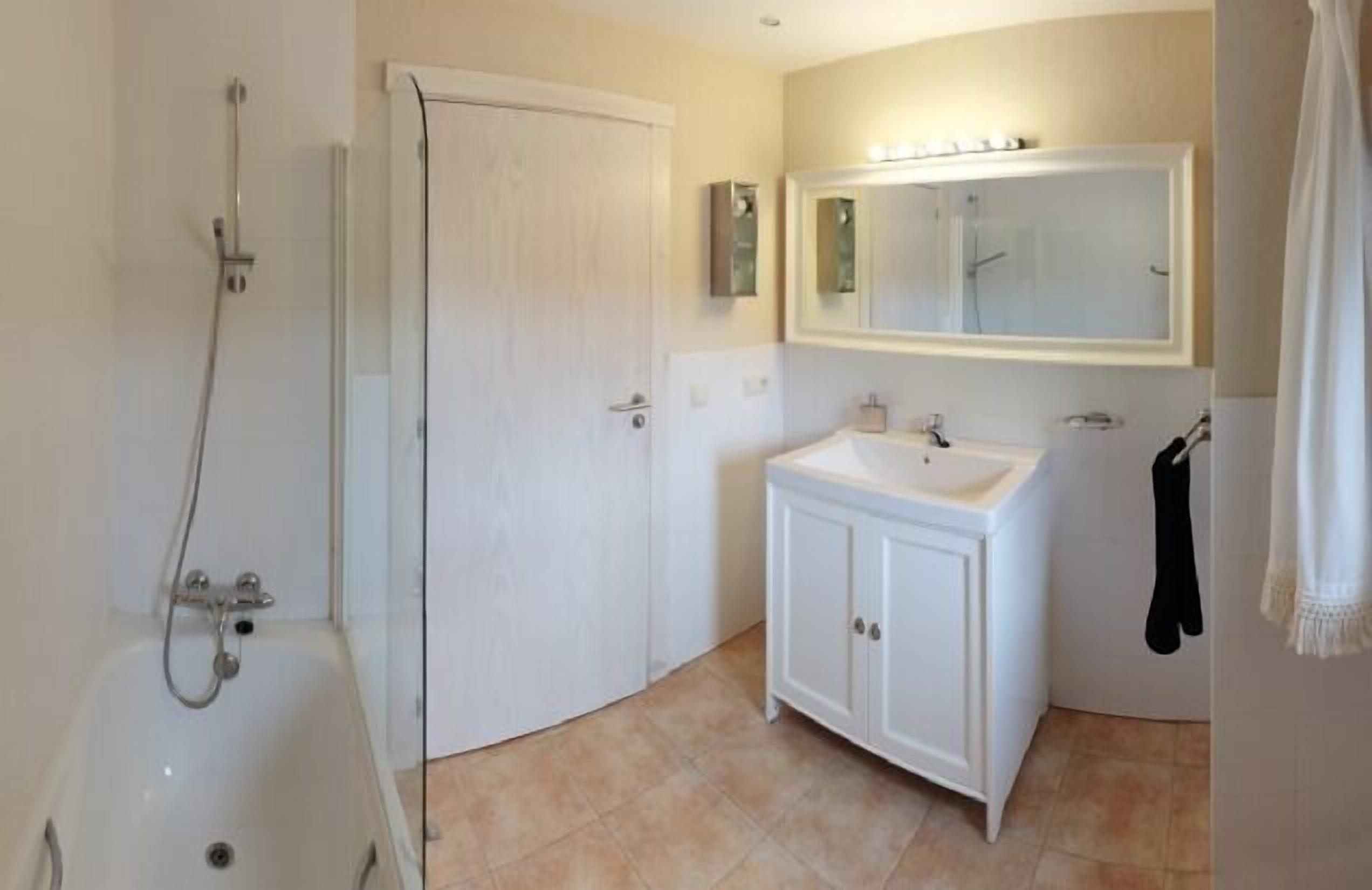 Une salle de bain avec une douche, un lavabo et un miroir.