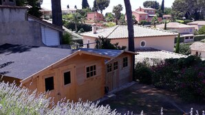 A rustic wooden building with a sloped roof, surrounded by lavender fields and tall trees. - Villa with sea access on foot!  Quiet and large shady garden (Sanary-Sur-Mer)