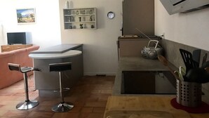 A modern kitchen with a bar area, a dining table, and a TV. - Villa with sea access on foot!  Quiet and large shady garden (Sanary-Sur-Mer)