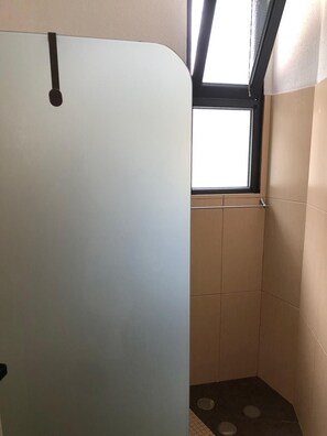 A bathroom with a window, tiled walls, and a door. - BARROS APARTMENT: Offers views of the ocean and mountains—visit Madeira’s many attractions. (Estreito De Câmara)