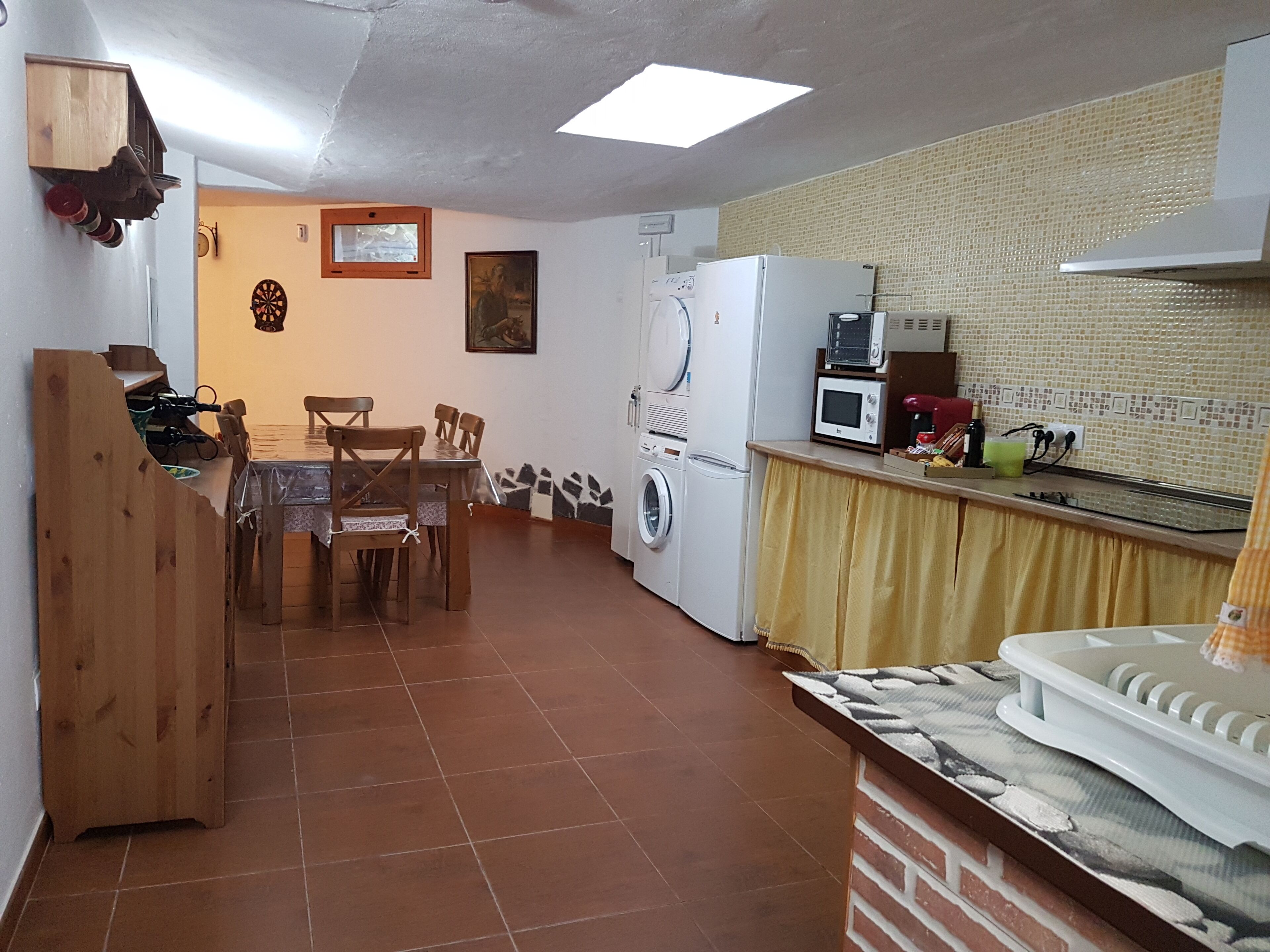 Une cuisine compacte comprenant un coin repas, un lave-linge et un four à micro-ondes.