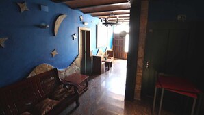 A room with a blue wall, wooden furniture, and a stone fireplace.