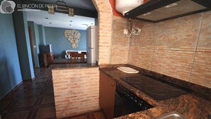 A kitchen with granite countertops, a stove, and a sink.