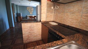 A kitchen with granite countertops, a stove, and a sink.