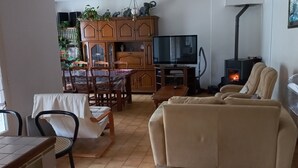 Ein Wohnzimmer mit Fernseher, Sofa und Kamin.