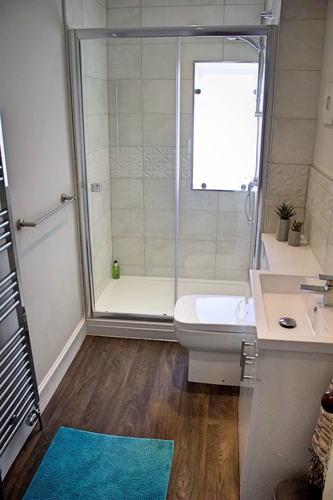 Un baño moderno con ducha de vidrio, inodoro y lavamanos.