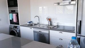 A modern kitchen with stainless steel appliances, a dishwasher, and a built-in oven. - Ribamar-Quinta Mar and Terra Villas (Ribamar)