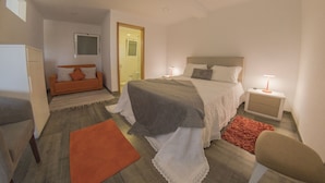 A bedroom with a bed, bedside tables, a nightstand, a sofa, a chair, and a window. - Ribamar-Quinta Mar and Terra Villas (Ribamar)