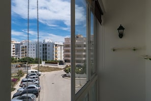 Vista da janela com vista para um estacionamento e edifícios.