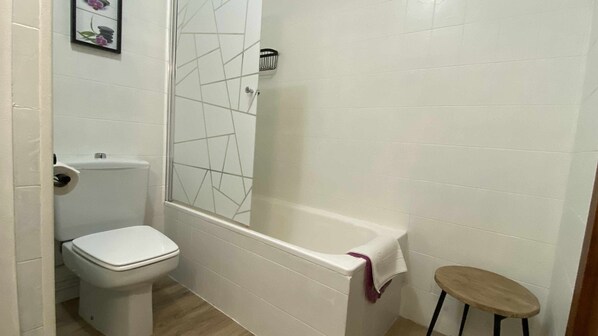 A bathroom with a toilet, a bathtub, and a small stool. - Casa Lola Beceite, terrace, barbecue and chimney (Beceite)