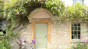A stone building with a green door and a bicycle parked outside. - Lovely property in the heart of Somerset (Wells)