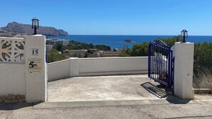 Une entrée sécurisée, avec vue sur la mer et une montagne en arrière-plan.