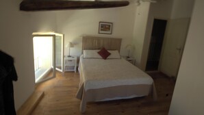 Una camera da letto con un letto, un comodino, una lampada, una finestra e una porta.