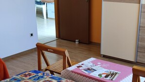 Un dormitorio con una cama, una puerta de madera y vista a otra habitación.
