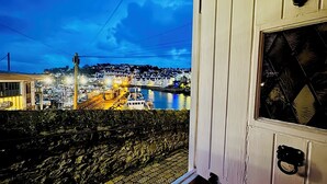 A room with a view of a waterfront at dusk. - Gorgeous Waterside Fisherman's Cottage, Free Parking, Harbour Views, Disney+ (Brixham)