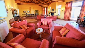A spacious living room with red sofas and a fireplace.