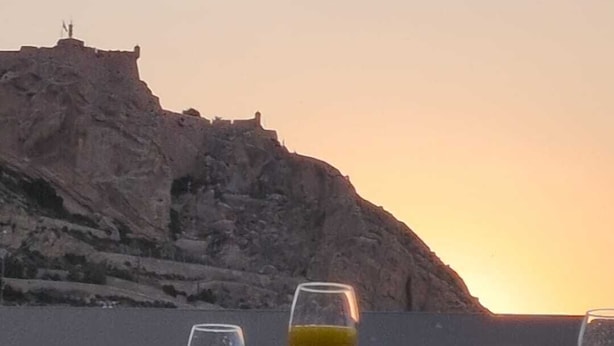 A table with drinks and snacks, overlooking a rocky cliff and the sea at sunset. - COZY AND SUNNY PENTHOUSE IN THE HEART OF THE CITY (Alicante)