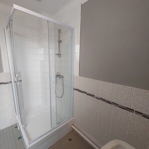 Een douche, handdoeken, zeep, toiletpapier