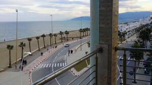 Eine Küstenstraße mit Palmen und einem Strand im Hintergrund.