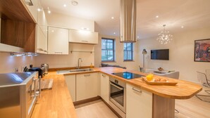 Una cocina moderna con una isla central, horno empotrado y electrodomésticos de acero inoxidable.