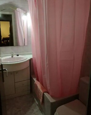 Een bad/douchecombinatie, een haardroger, een bidet, handdoeken