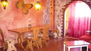 A dining area with a wooden table and chairs, a decorative tiger statue, and wall-mounted lights. - chalet bougainvillea sea view 500 m. from the beach available wifi (Almuñécar)