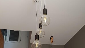 A staircase with a wooden handrail and a modern light fixture with three bulbs. - MIRADORES DEL ISASA - VIURA-NEOSENS STUDIO APARTMENT (HERCE, La Rioja)
