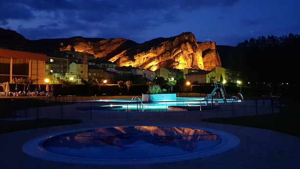 A pool area with a circular water feature, a pool ladder, and a mountain backdrop. - MIRADORES DEL ISASA - VIURA-NEOSENS STUDIO APARTMENT (HERCE, La Rioja)