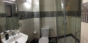 A bathroom with a glass-enclosed shower, a toilet, and a sink with a mirror. - Central Station House "Mario", confort and charme!  (Catania)