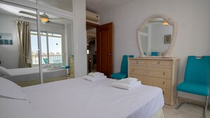 Ein Hotelzimmer mit Bett, Schminktisch, Spiegel und Stuhl.