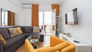 A modern living room with a sofa, armchair, and a glass coffee table.