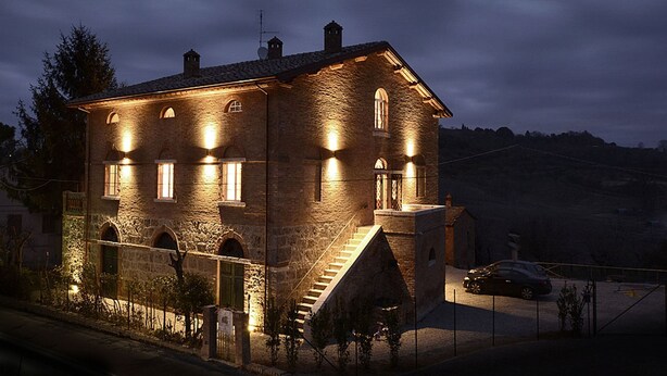 A stone building with multiple windows and a staircase leading to the entrance.