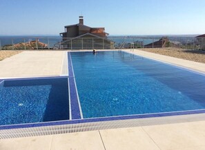A rectangular pool with clear blue water, surrounded by a tiled deck.