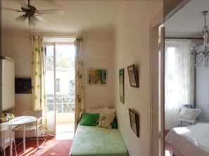 A bedroom with a bed, a desk, a chair, and a balcony with curtains. - Idyllic flat Cannes, sea view, 1. 200km Croisette, very calm (Cannes)