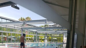A swimming pool area with clear water, a diving board, and a lifeguard stand. - Idyllic flat Cannes, sea view, 1. 200km Croisette, very calm (Cannes)