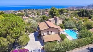 Una casa con piscina, immersa nel verde e con vista mare.