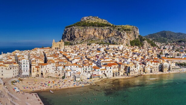 Un borgo costiero con una scogliera imponente e una spiaggia.