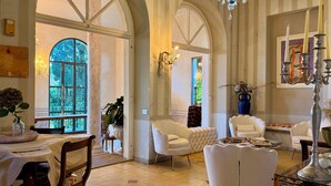 Una habitación amplia con techos altos, ventanas grandes y muebles elegantes.