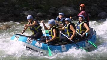 Un grupo de personas en un bote inflable azul sobre un río.