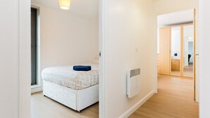 A bedroom with a bed, a radiator, and a window. - Skyline Birmingham City Centre Penthouse (Birmingham)