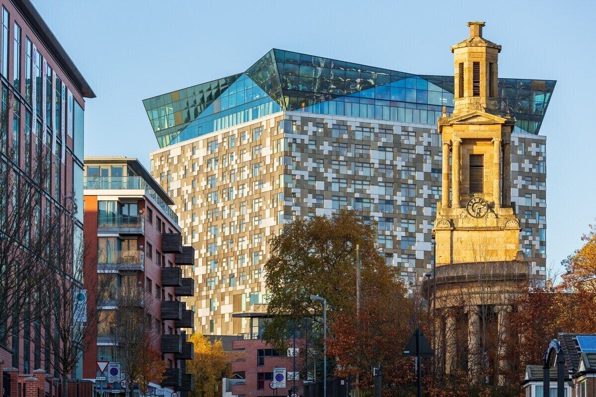 Ein modernes Gebäude mit Glasfassade und einem Uhrturm.